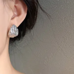 Close-up of silver water drop earrings with wrinkled texture on Asian model