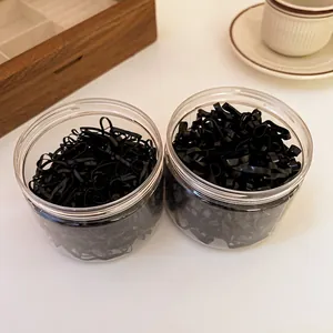 Detailed view of black disposable elastic hair bands in two clear plastic jars