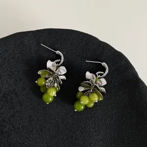 Detailopname van elegante Mori-stijl druiventros oorbellen met groene glazen kralen en zilveren