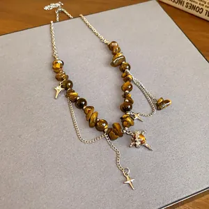 Close-up detail of vintage tiger eye stone necklace featuring stainless steel star pendants