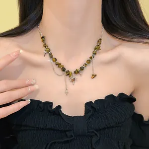 Detail shot of a vintage tiger eye stone necklace with star pendants on a model's neck