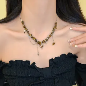 Macro view of the irregular tiger's eye and star charms on this vintage steel necklace.