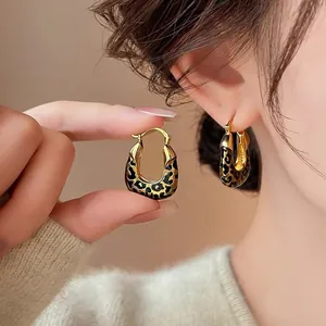 Close-up of elegant leopard print hoop earrings with vintage oil-drop finish