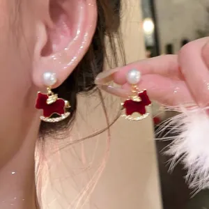 Red flocked rocking horse stud earrings with white pearl and gold-tone base frame