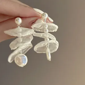 Dettaglio di orecchini a perla in chiffon con eleganti strati di tessuto bianco