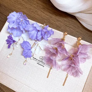 Vue détaillée d'élégantes boucles d'oreilles à fleurs en maille violette avec perles