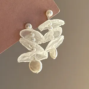 Vista dettagliata di eleganti orecchini in chiffon francese con perle bianche lucide