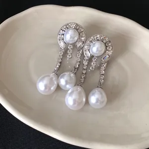 Gros plan de boucles d'oreilles avec perles élégantes et zircons scintillants