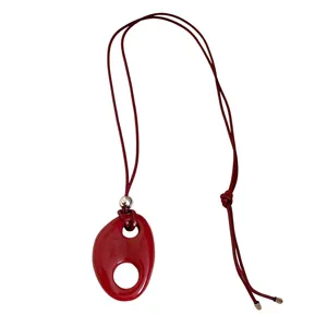 Collier avec pendentif ovale creux en résine rouge au style vintage ethnique sur blanc