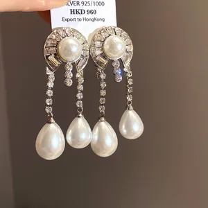 Vue détaillée de boucles d'oreilles en argent avec perles et strass scintillants