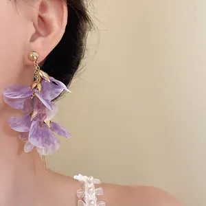 Gros plan de boucles d'oreilles à pampilles en maille violette, style doux et féerique.