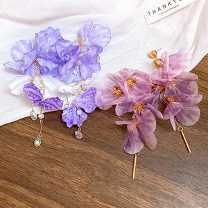 Détail de boucles d'oreilles à pampilles en fleurs de maille violettes et lavande