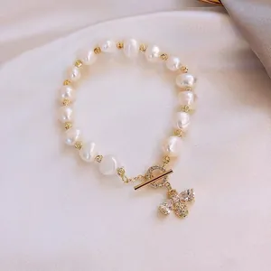 Close-up detail of a baroque pearl bracelet featuring a sparkling zircon bee charm