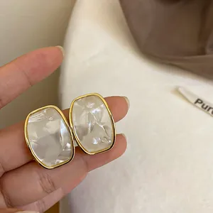 Eleganti orecchini a lobo geometrici in resina bianca e montatura oro