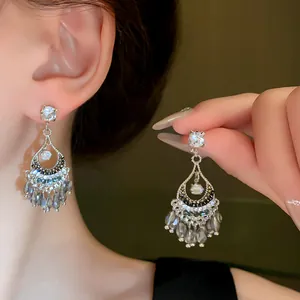 Primo piano di eleganti orecchini a nappa in cristallo argento con strass molto brillanti