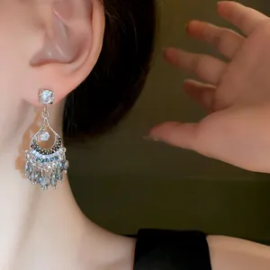 Dettaglio di eleganti orecchini a nappa in cristallo argento con intarsi di diamanti
