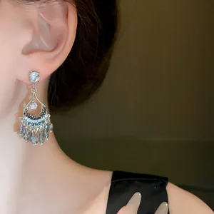 Vista dettagliata di eleganti orecchini con nappe di cristallo e design etnico argento.