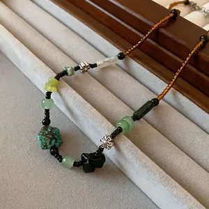 Detail of a New Chinese style necklace with green turquoise beads and silver flowers