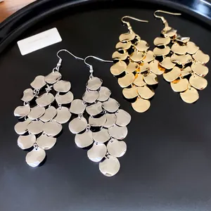Close-up of irregular leaf-shaped tassel dangle earrings in gold and silver finish
