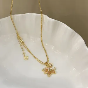 Close-up of a gold-plated horse pendant necklace with sparkling zircons on a white tray