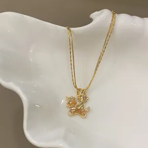 Close-up detail of a gold-plated necklace with a zircon-encrusted pony pendant charm.