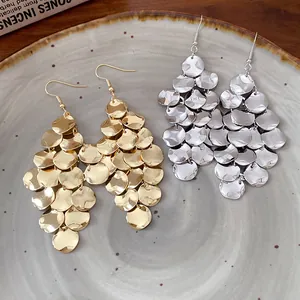 Detailed view of bohemian style metal sequin tassel earrings in gold and silver finish