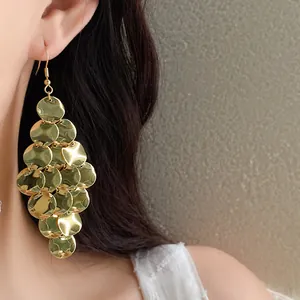 Elegant gold dangling earrings with hammered metal disks in a tiered tassel design