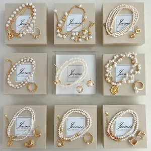 Macro view of several elegant pearl jewelry sets including necklaces and earrings on beige boxes