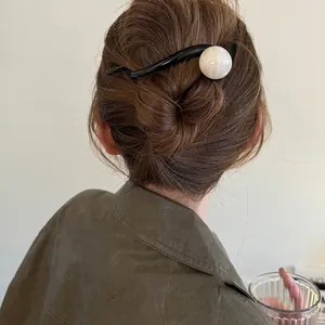 Gros plan détaillé d'une pince à cheveux rétro élégante avec une perle en marbre blanc