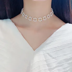 Elegant French style pearl choker necklace with flower patterns on a model's neck