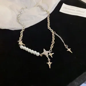 Macro view of a silver necklace with lustrous white pearls and shimmering star charms.