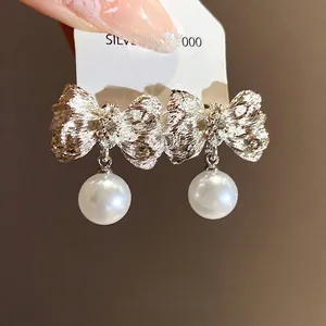 Elegant silver pleated bow earrings with white pearl pendants in a vintage luxury style