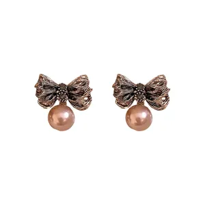 Elegant vintage style wrinkled metal bow earrings featuring soft pink pearl pendants