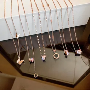 Rose gold titanium steel necklaces with varied pendants on white gift box background