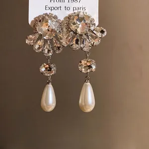 Elegantes pendientes de flor con diamantes de imitación y perlas de gota en plata