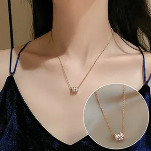 Detail shot showing a gold titanium steel necklace with a crystal-studded pendant.