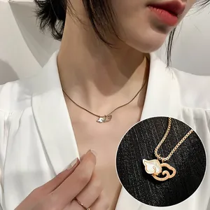 Close-up detail of a rose gold titanium steel necklace with shell inlay heart pendant
