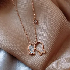 Close-up detail of an elegant rose gold titanium steel necklace with rhinestone gourd pendants