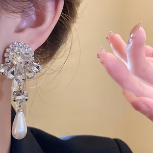 Vista detallada de pendientes de plata con flor de diamantes y perla gota