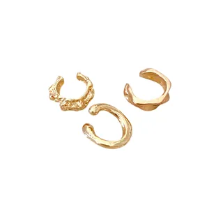 Minimalist set of three irregular golden ear cuffs featuring unique textured designs.