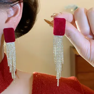 Detailed close-up of elegant red flocked square earrings with shimmering rhinestone tassels