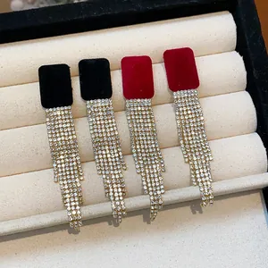 Detail shot of flocked square stud earrings with cascading rhinestone tassels in red and black.