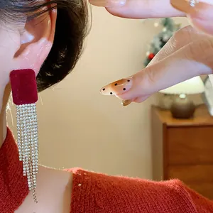Detail view of red velvet square earrings with shimmering rhinestone tassels