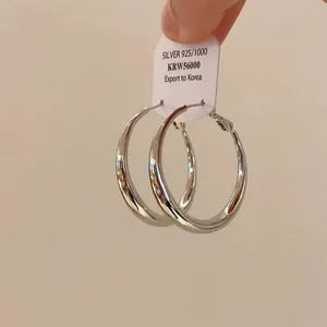 Detail view of high-quality minimalist silver hoop earrings with a polished finish