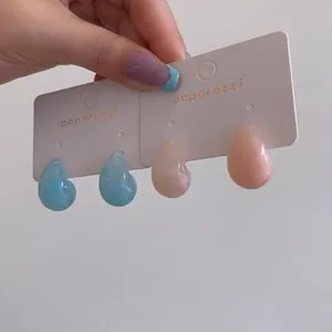 Elegant minimalist resin water drop stud earrings available in blue and peach pink