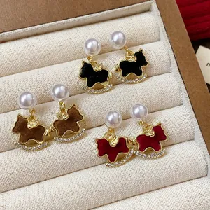 Detail view of pearl rocking horse earrings with crystal accents in a jewelry tray