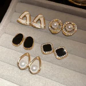 Macro view of 10-piece vintage pearl and rhinestone stud earrings set in jewelry tray