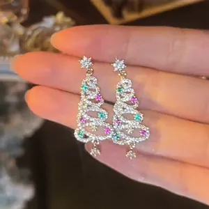 Close-up of sparkling Christmas tree earrings with colorful zircon and stars