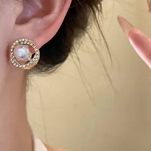 Close-up of an elegant French retro gold-tone earring with pearl and rhinestones