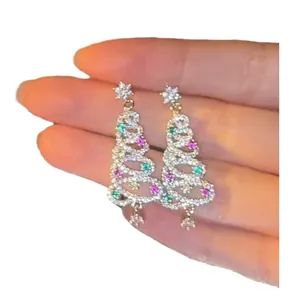 Sparkling Christmas tree earrings with colorful zircon and snowflake details on a silver needle.
